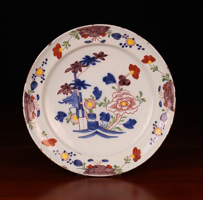 A Late 18th/Early 19th Delft Plate decorated in polychrome glazes with flowers and measuring 13¼ in