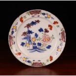 A Late 18th/Early 19th Delft Plate decorated in polychrome glazes with flowers and measuring 13¼ in