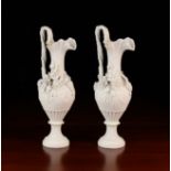 A Pair of Victorian Parian Ewers encrusted with finely modelled flowers and bunches of grapes,