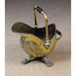 A Victorian Brass Helmet-shaped Coal Scuttle embossed and chased with bold foliate designs and