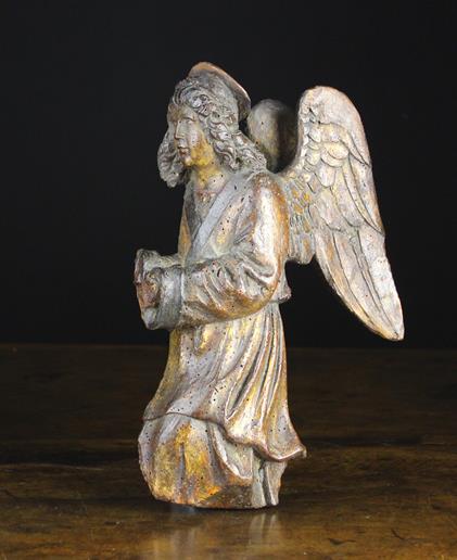 A 16th Century Polychromed Wood Carving of a kneeling angel relief carved in profiled depicted with