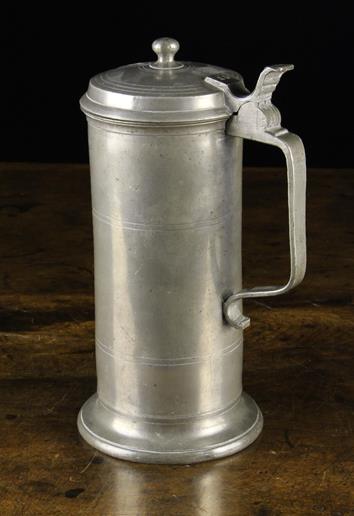 An Antique Pewter Flagon having a hinged lid with finial knop and strap handle stamped with