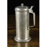 An Antique Pewter Flagon having a hinged lid with finial knop and strap handle stamped with