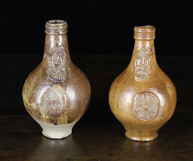 Two 17th Century Stoneware Bartmannkrugs with bearded face masks above oval rosette medallions,