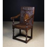 A Joined Oak Wainscot Chair enriched with carving and having an inlaid flowering plant to arcaded