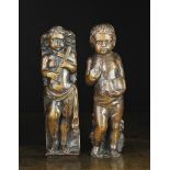 Two 17th Century Flemish Oak Figural Pilasters carved in the form of putti; one holding a cross,