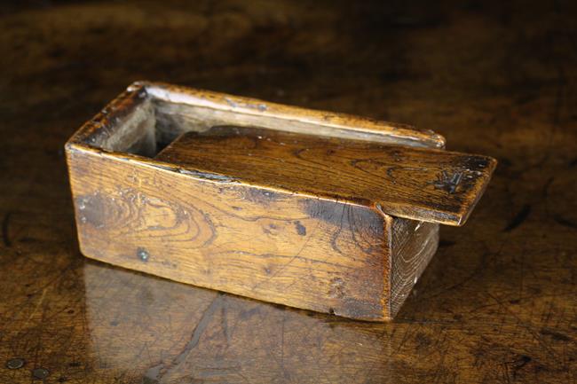 A Small Dug-out Elm Box of rectangular form with sliding lid, 2 in (5 cm) high, 5¼ in (13 cm) long,