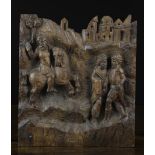 A 16th Century Antwerp Oak Carving depicting three men in landscape with town in distance;