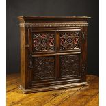 An Attractive 17th Century Joined Oak Mural Cupboard with later pierced and carved panels.