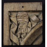 A Gothic Oak Spandrel Circa 1500, carved with a Prophet entwined in a scrolling banner,