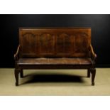 An 18th Century Joined Oak Settle having a four paneled back with ogee moulded corners,