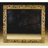 A Large Rectangular Wall Mirror in a 17th century pierced oak frame richly carved with winged