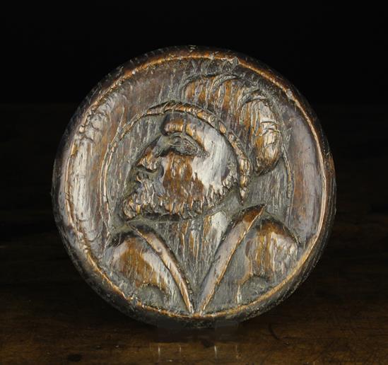 A 16th Century Carved Oak Portrait Roundel depicting a man's head in profile,