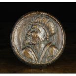 A 16th Century Carved Oak Portrait Roundel depicting a man's head in profile,