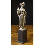 A Renaissance Cast Bronze Figure of a curly haired angel depicted wearing a long flowing robe with