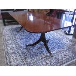 A good 20th century Regency style dining table with two leaves on twin tripod bases originally