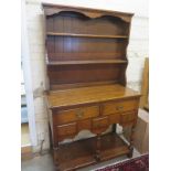 A reproduction oak dresser, plate rack over two long drawers above three short,