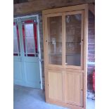 A modern oak display cabinet with four sliding doors and glass shelves - 214cm x 91cm
