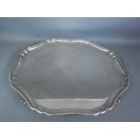 A hallmarked silver Sterling tray raised on four scroll feet with pie-crust boarder monogrammed