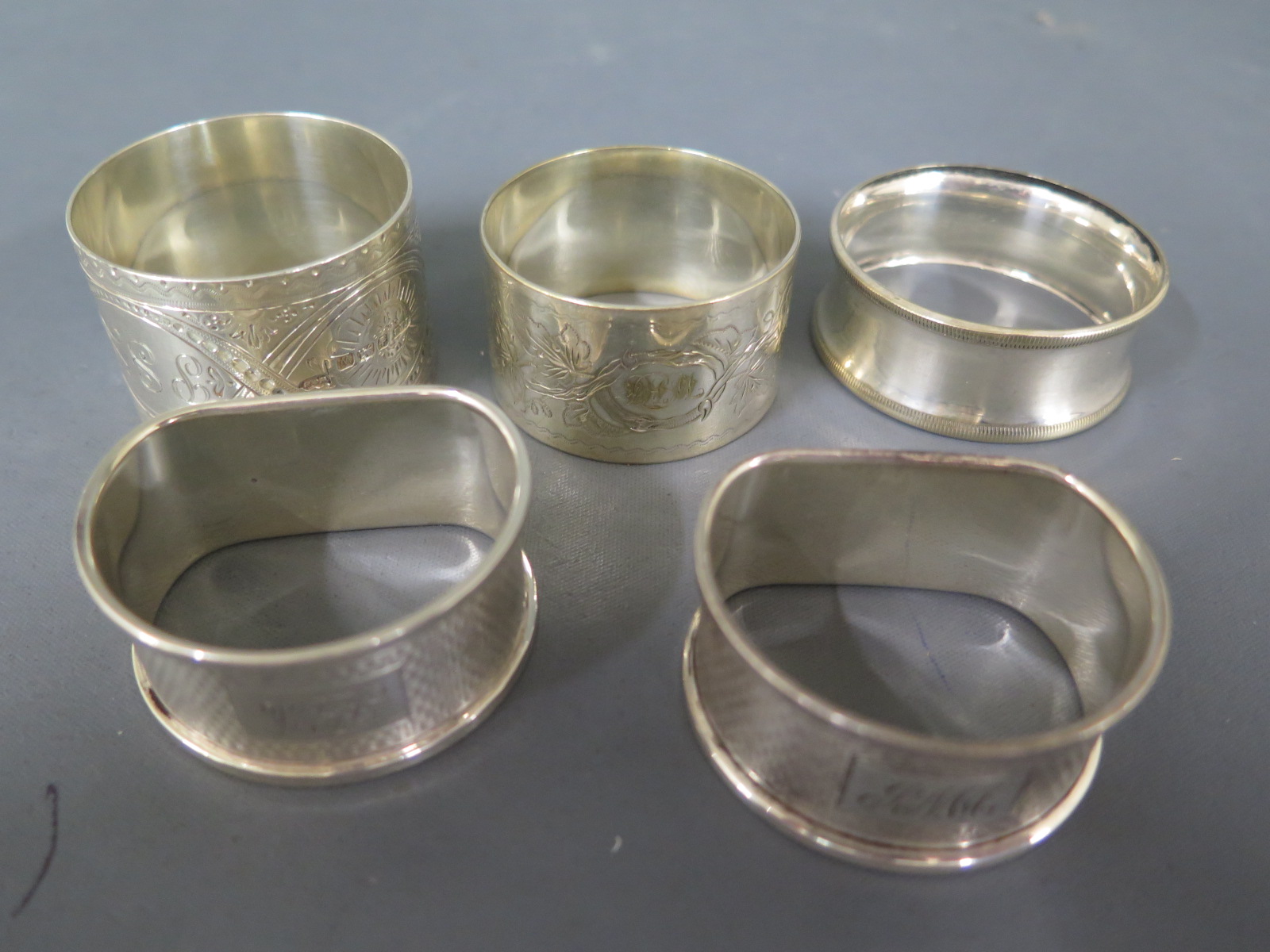 Three silver hallmarked napkin rings and two silver plated