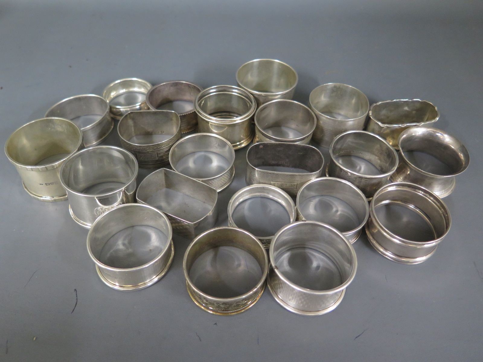 Twenty two silver hallmarked napkin rings, varying design and size - Weight approx.