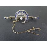An early 20th century yellow gold diamond and sapphire crescent brooch with a central pearl,