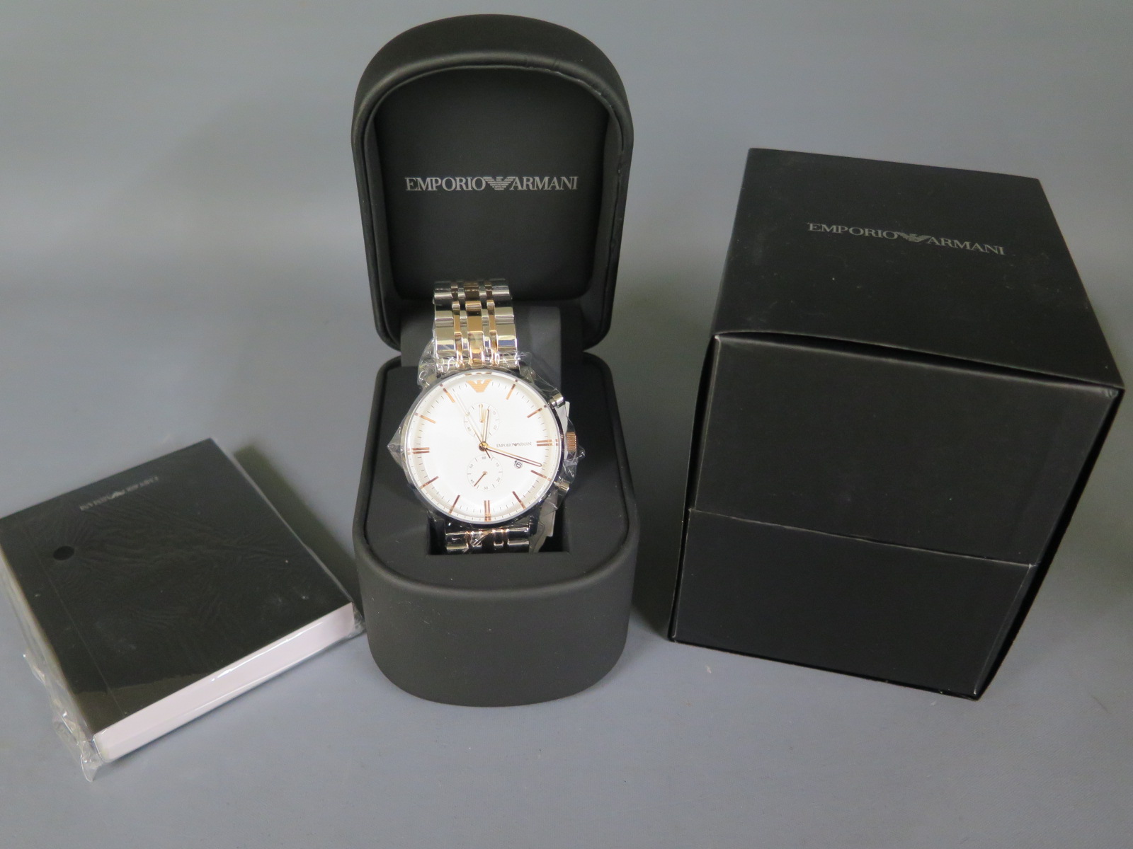 A new Emporio Armani gents wristwatch with boxes and papers