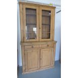 A 19th century pine cabinet with two glazed doors over two drawers and two cupboard doors - Height