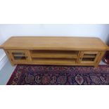 A modern oak TV cabinet with two glazed cupboard doors - 50cm x 180cm x 40cm