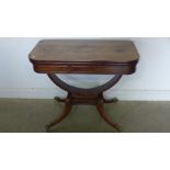 A Regency mahogany foldover card table on a U shaped support and quatrefoil splayed legs