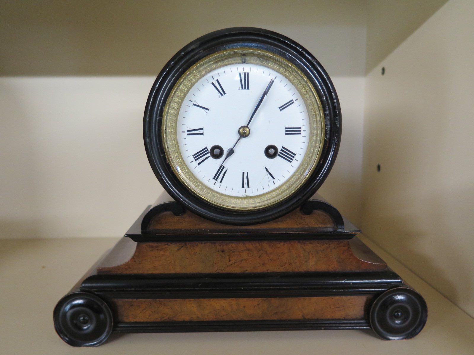 A 19th century walnut and ebony French mantle clock with 8 day movement strikes on a bell,