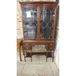 A 20th century mahogany parlour cabinet with a glazed two door top on a four drawer base with