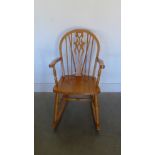 A stained rocking chair with pierced splat