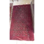 A hand knotted woolen rug with a red field - 175cm x 95cm - some small wear