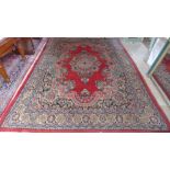 A large Persian rug, red ground with floral decoration,