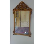 A modern gilt painted wall mirror carved and pierced top - Width 55cm x Height 102cm