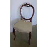A Victorian mahogany balloon back chair with overstuffed seat raised on cabriole supports