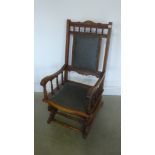 A beech framed American rocking chair with dark green leatherette splat and seat