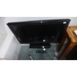A Sony flat screen TV model KDL-3255500 on glass stand - in working order