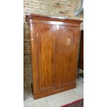 A Victorian framed mahogany veneered twin door wardrobe cornice over two doors on plinth base,