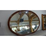 An Edwardian oval wall mirror - 93cm x 65cm