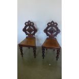 A pair of 19th century mahogany hall chairs on carved turned supports