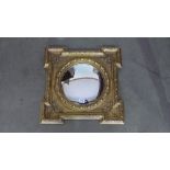 A small gilt mirror with round glass and decoration - 43cm x 43cm