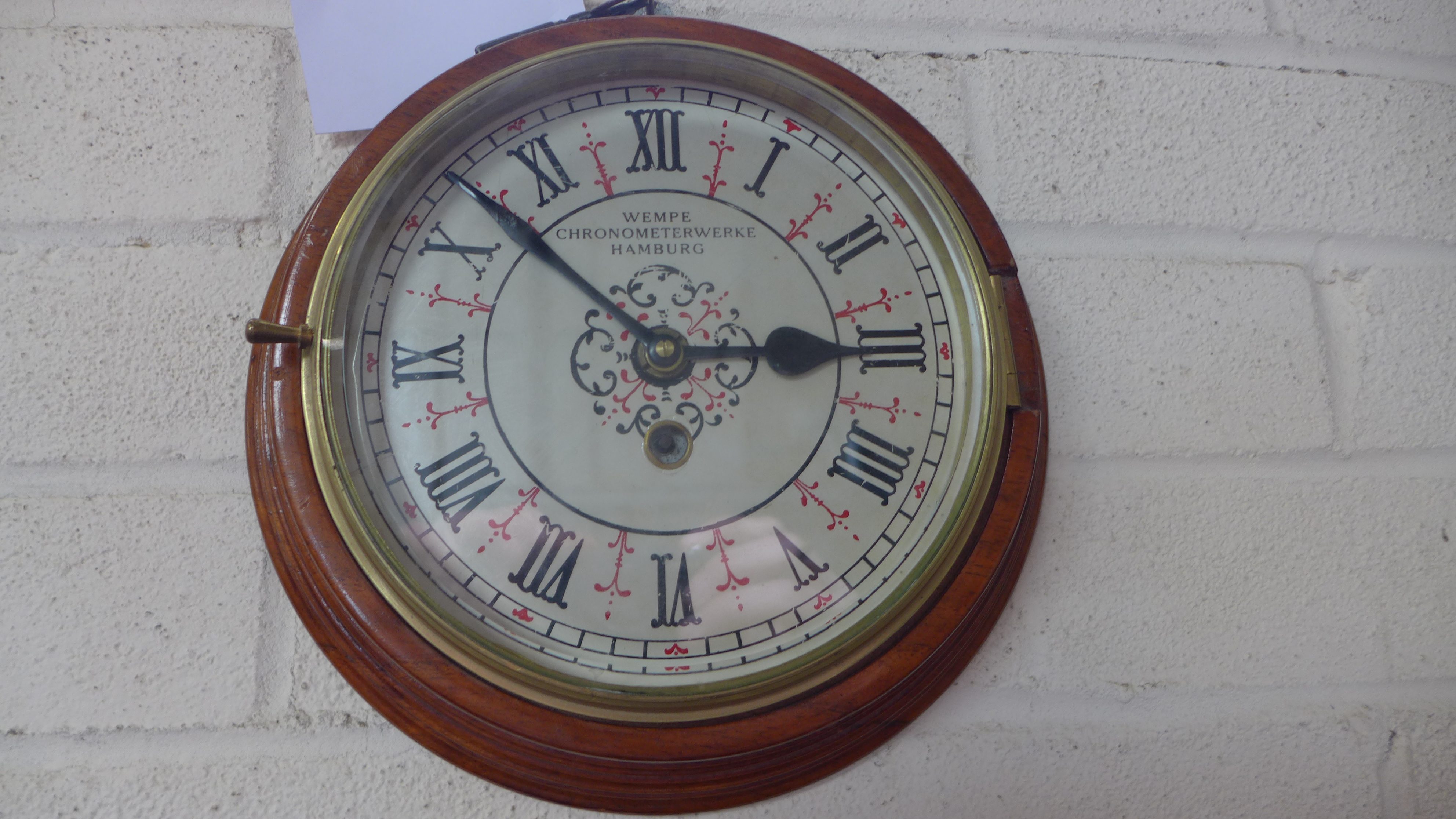 A German wall clock with a painted dial - Diameter 25cm - working in the saleroom