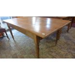 A Victorian stripped pine kitchen table with an end drawer on turned legs with a replaced top -