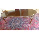 An Edwardian windout walnut oval table with two leaves on carved shaped legs and ball and claw feet