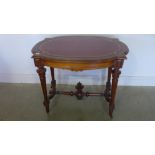 A 19th century walnut freestanding table with a shaped top and leather inset on turned reeded legs