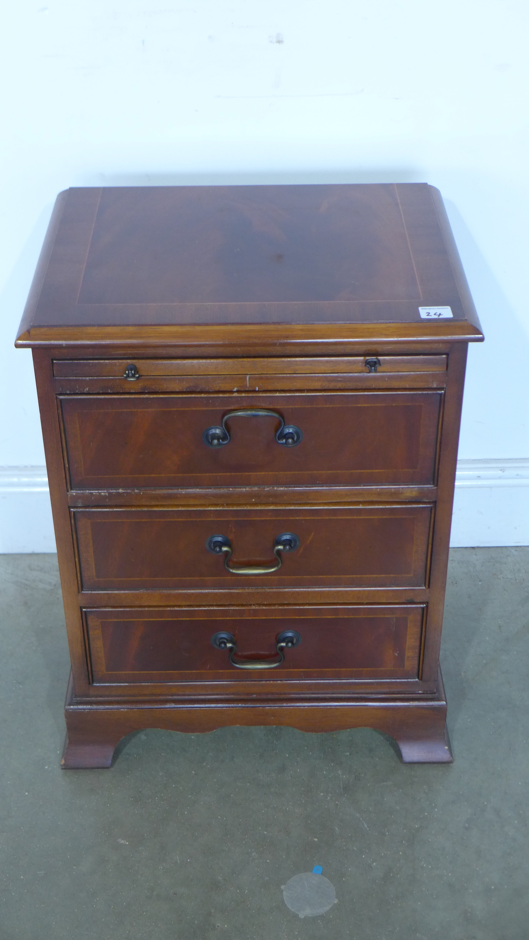 A reproduction three drawer chest raised on bracket supports, brushing slide to top - 46cm x 34.