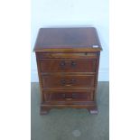 A reproduction three drawer chest raised on bracket supports, brushing slide to top - 46cm x 34.