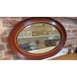 A faux mahogany oval mirror - 82cm x 56cm